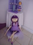 Mesa de canto com doces e boneca sentada no baú de vime