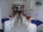 Entrada do salão com decoração das mesas com tolhas e cobre mancha coloridos e cadeiras com fantasminhas e fitas .