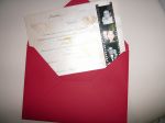 Envelope vermelho, convite em papel perolado com negativo de fotos dos noivos em um dos lados, ao fundo do texto desenho de rosas