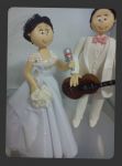 Cd:N206
 a noiva cantando e noivo com terninho branco tocando violo..