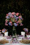 Mesa de doces finos, acompanha decoração de flores liláses.Doc.3-BO