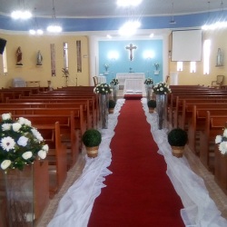 Decoração corredor para cerimônia de casamento com arranjos artificiais.