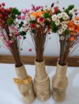 Centro de mesa Garrafas decoradas com sisal e juta. Iniciais ou fita/fio com contas/caracol e meias pérolas. Mini ramalhete de florzinhas coloridas a parte.